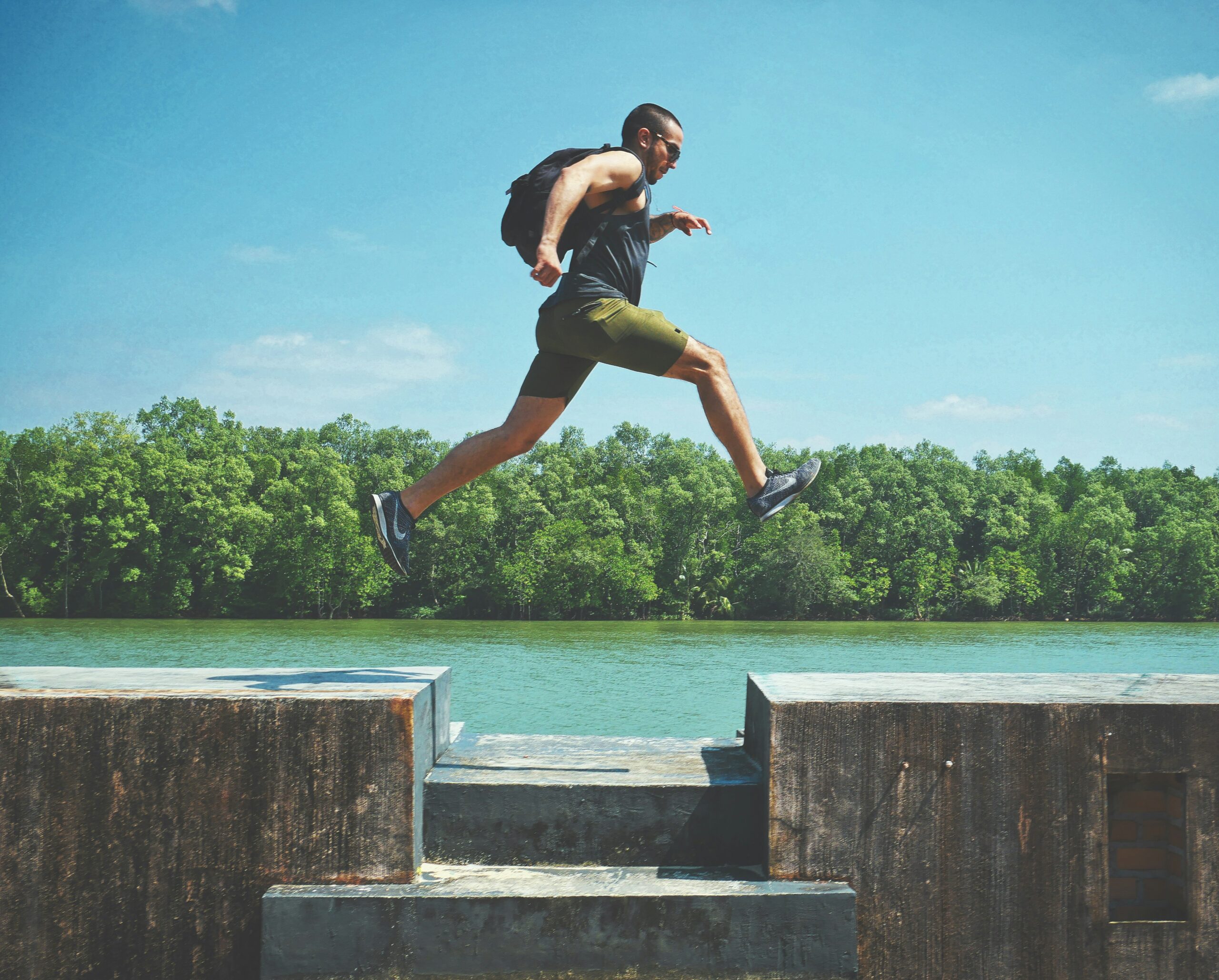 Image of man running on blocks across a river